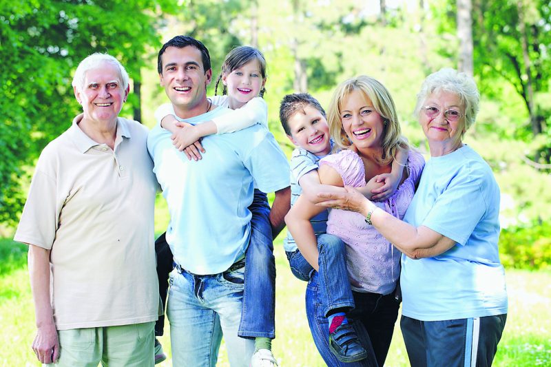 Portrait of a extended happy family standing in the park.