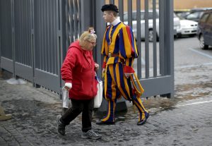 A homeless woman walks past a Swiss guard as she enters the Vatican March 26. While enjoying a private visit to the Sistine Chapel, homeless people were surprised by a visit from Pope Francis. (CNS photo/Max Rossi, Reuters) See HOMELESS-SISTINE (UPDATED) March 27, 2015.