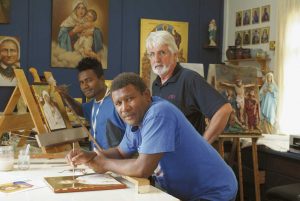 Artist and studio director Michael Pervan watches as Solomon Islands artists  Stephen Maetora (left) and Liborio Maemauri work on their icons.