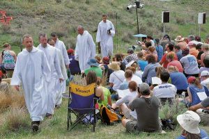 Br Alois, the abbot of the Taizé Community in France, leads worshippers out of the natural amphitheatre worship space after Morning Prayer at the Pine Ridge Indian Reservation in southwestern South Dakota. (Photo: Mary  Frances Schjonberg-Episcopal News Service)