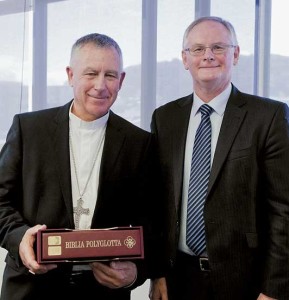 Cardinal John Dew receives the Polyglot Bible from Bible Society CEO Francis Burdett.