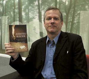 Dr Kevin Yuill with a copy of his book that outlines why assisted suicide is not a good idea.