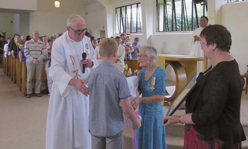 Msgr David Price commends Anne Nightingale while her grand nephew, William Partington, presents
her with flowers and
her niece, Carmel Jones, holds her Benemerenti certificate.