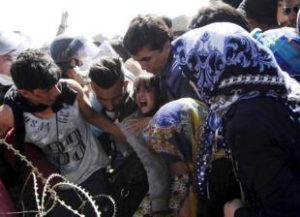 A young girl screams as migrants rush to cross into Macedonia at the Macedonian-Greek border Sept. 2. Catholic aid agencies have urged Europeans not to turn against migrants seeking refuge from Syria and other countries, in what media reports describe as the continent's greatest refugee movement since World War II. (CNS/Ognen Teofilovski, Reuters) See EUROPE-REFUGEES-CHURCH Sept. 4, 2015.