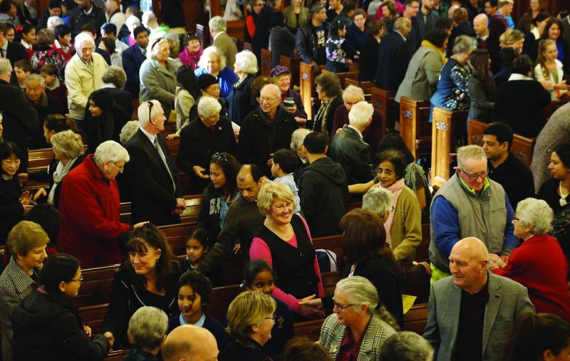Caring Mass worshippers exchange the Sign of Peace (photo by Rochelle Dias, Auckland Youth and Young Adult Ministry).