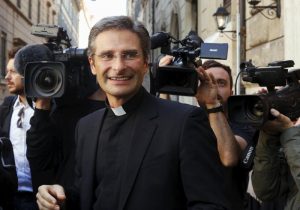 Msgr. Krzysztof Charamsa smiles as he leaves a news conference he called Oct. 3 to announce he is gay and has a partner. The Vatican spokesman said, given Msgr. Charamsa's public announcement, it would be impossible for the monsignor to continue working at the Vatican or teaching at pontifical universities.(CNS photo/Alessandro Bianchi, Reuters) See VATICAN-CHARAMSA-HOMOSEXUALITY Oct. 5, 2015.