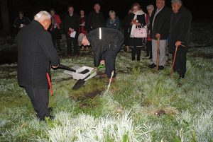Papakura parish priest Fr Peter Murphy completes the turning of the first sod, saved in the box at his feet. The sod will be used when the school is blessed and opened in January 2017.
