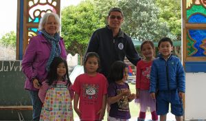 Former Marian Early Childhood Centre supervisor Trudi Lynch and Cyril Siasoco with four of the centre’s children. Some illustrated woodlight panels are behind them. 