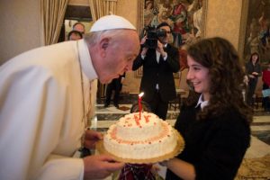 Pope Francis blows out the candle on a birthday cake presented by a young member of the Italian branch of Catholic Action during an audience with the group at the Vatican Dec. 17. The pope celebrated his 79th birthday Dec. 17. (CNS photo/L'Osservatore Romano, handout) See POPE-CATHOLIC-ACTION Dec. 17, 2015.