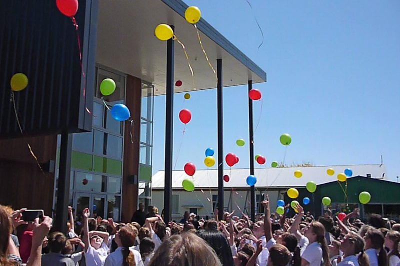 Children release balloons at the school opening.