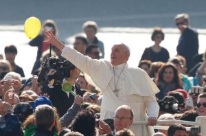 Pope Francis reaches for a balloon released by someone in the crowd during his general audience in St. Peter's Square at the Vatican March 30. The power of God's forgiveness "is greater than our sins," the pope said in his audience talk. (CNS photo/Paul Haring) See POPE-AUDIENCE-FORGIVENESS March 30, 2016.