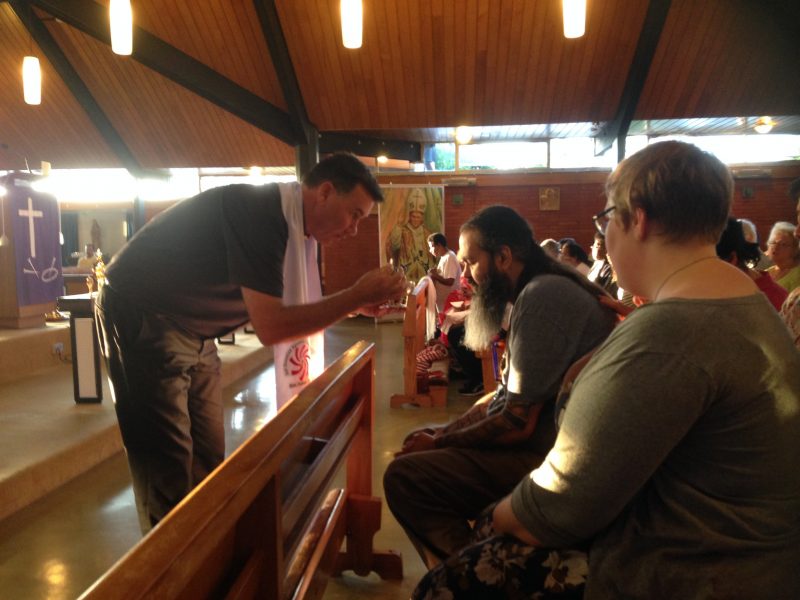 Australian priest Fr Andrew Grace gives Communion to former satanist Zac King.