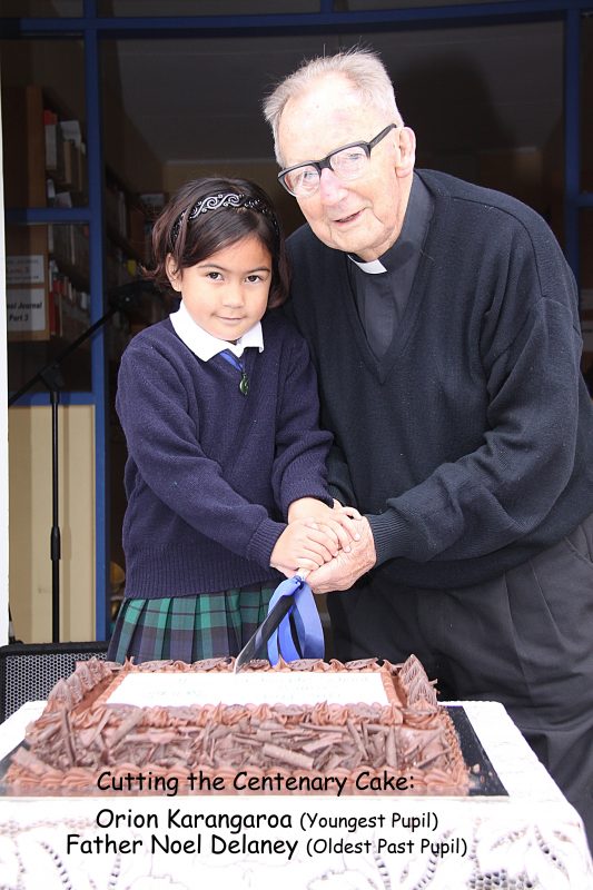 Fr Noel Delaney, SM, cuts a cake at a school celebration.