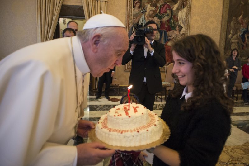 Pope Francis blows out the candle on a birthday cake presented by a young member of the Italian branch of Catholic Action during an audience with the group at the Vatican Dec. 17. The pope celebrated his 79th birthday Dec. 17. (CNS photo/L'Osservatore Romano, handout) See POPE-CATHOLIC-ACTION Dec. 17, 2015.
