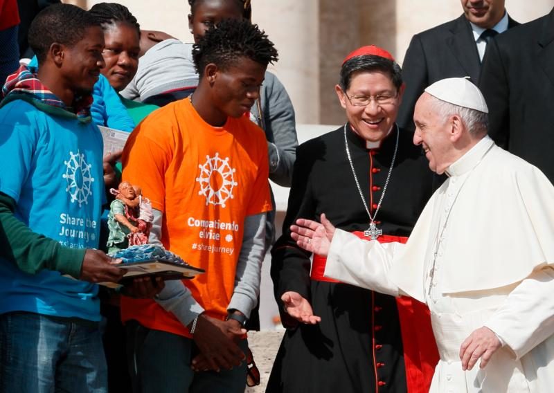 Pope Francis greets Cardinal Luis Antonio Tagle of Manila, Philippines, and immigrants during his general audience in St. Peter's Square at the Vatican Sept. 27. Immigrants were in attendance as Caritas Internationalis launched its "Share the Journey" campaign in support of immigrants. (CNS photo/Paul Haring) See POPE-AUDIENCE-SHARE-HOPE and POPE-SHARE-JOURNEY Sept. 27, 2017.