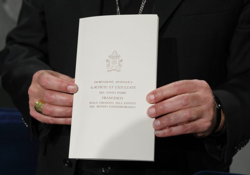 Archbishop Angelo De Donatis, papal vicar for the Diocese of Rome, holds a copy of Pope Francis' exhortation, "Gaudete et Exsultate" ("Rejoice and Be Glad"), during a news conference on the exhortation at the Vatican April 9. The document is on the "call to holiness in today's world." (CNS photo/Paul Haring) See POPE-HOLINESS April 9, 2018.