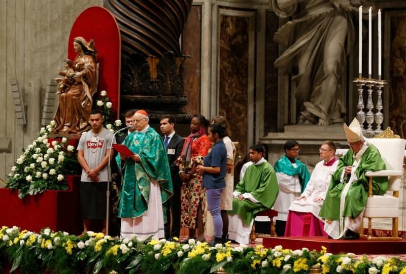 Pope Francis looks on as Cardinal Lorenzo Baldisseri, secretary-general of the Synod of Bishops, reads a letter from the synod fathers to young people during the closing Mass of the Synod of Bishops on young people, the faith and vocational discernment in St. Peter's Basilica at the Vatican Oct. 28. (CNS photo/Paul Haring) See SYNOD-POPE-MASS-CLOSE and SYNOD-LETTER-YOUNG-PEOPLE Oct. 28, 2018.