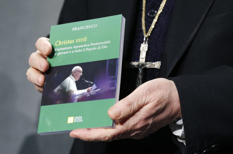 Cardinal Lorenzo Baldisseri, secretary-general of the Synod of Bishops, holds Pope Francis' apostolic exhortation, "Christus Vivit" (Christ Lives), during a news conference for its presentation at the Vatican April 2, 2019. The document contains the pope's reflections on the 2018 Synod of Bishops on young people, the faith and vocational discernment. (CNS photo/CNS photo/Paul Haring) See POPE-EXHORTATION-YOUNG April 2, 2019.