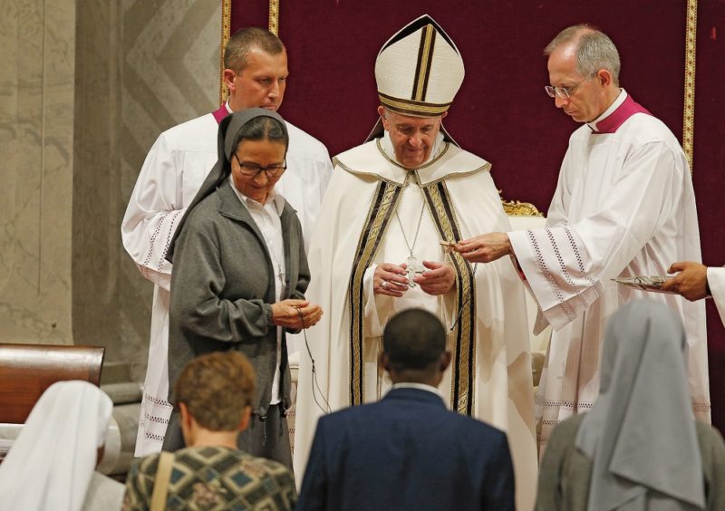 Pope Francis presents crosses to new missionaries during a prayer vigil opening a month dedicated to missionaries, in St. Peter's Basilica at the Vatican Oct. 1, 2019. (CNS photo/Paul Haring) See POPE-MISSIONARY-VESPERS Oct. 1, 2019.