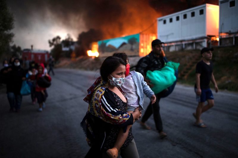 A displaced woman and child flee after fires broke out at the Moria refugee camp on the island of Lesbos, Greece, Sept. 9, 2020. The camp, which was mostly destroyed, was home to at least 12,000 people, six times its maximum capacity of just over 2,000 asylum-seekers.(CNS photo/Alkis Konstantinidis, Reuters)