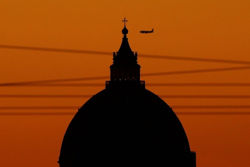 A plane flies over the dome of St. Peter's Basilica during sunset at the Vatican Aug. 19, 2020. (CNS photo/Guglielmo Mangiapane, Reuters)