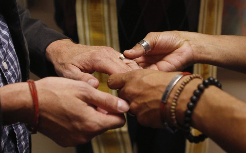 A same-sex couple is pictured in a file photo exchanging rings during a ceremony in Salt Lake City. In a new documentary, Pope Francis expressed openness to the idea of laws recognizing civil unions, including for gay couples, to protect their rights.(CNS photo/Jim Urquhar, Reuters)