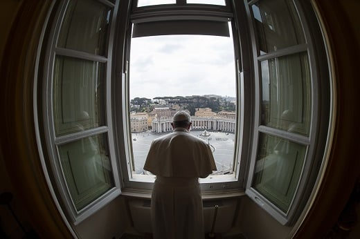 Standing in the window of the library of the Apostolic Palace overlooking an empty St. Peter's Square, March 29, 2020, Pope Francis blesses the city of Rome, which was under lockdown to prevent the spread of the coronavirus. Italy's new COVID-19 restrictions over the holidays have forced some changes to Pope Francis' Christmas schedule.  (CNS photo/Vatican Media)