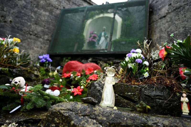 An angel and statue of Mary are pictured at a cemetery in Tuam, Ireland, where the bodies of nearly 800 infants were uncovered at the site of a former Catholic home for unmarried mothers and their children. The photo was taken Jan. 12, 2021, the day a commission investigating the treatment of women in such homes released its report. (CNS photo/Clodagh Kilcoyne, Reuters)