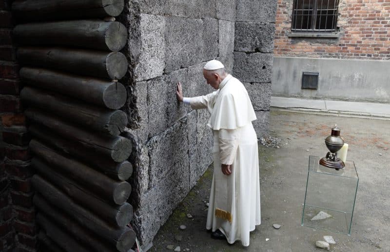 Pope Francis touches the death wall at the Auschwitz Nazi death camp in Oswiecim, Poland, in this July 29, 2016, file photo. The pope said remembering the Holocaust and its victims is not only an "expression of humanity" but also makes people aware that such horrors may happen again. The pope's comments came at his general audience as he commemorated International Holocaust Remembrance Day Jan. 27. (CNS photo/Paul Haring)