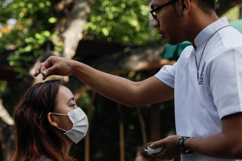 A woman wearing a protective mask receives ashes on top of her head during Ash Wednesday Mass at the National Shrine of Our Mother of Perpetual Help in Manila, Philippines, Feb. 26, 2020, during the COVID-19 pandemic. The Cebu Archdiocese in the central Philippines released a prayer guide Feb. 10 for the celebration of Ash Wednesday at home for those unable to go to church due to COVID-19 restrictions. (CNS photo/Eloisa Lopez, Reuters)