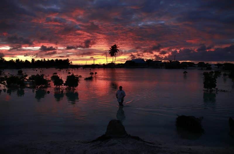 A villager wades through a small lagoon, which at high tide laps at the base of homes, near the village of Tangintebu on South Tarawa in the central Pacific island nation of Kiribati May 25, 2013. Pope Francis said island nations need protection from extreme environmental and climate changes. (CNS photo/David Gray, Reuters)