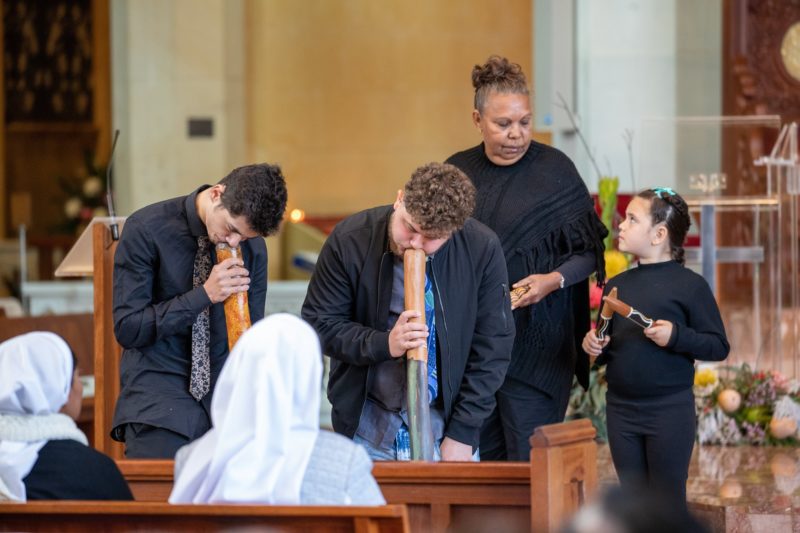 Digeridoo players Brandon Jansen, and his brother Thairon Jansen, perform  together with Donna Ryder and a child during the opening Mass of the First Plenary Council at St. Mary's Cathedral in Perth, Australia, Oct. 3, 2021. (CNS photo/Ron Tan, courtesy Archdiocese of Perth)