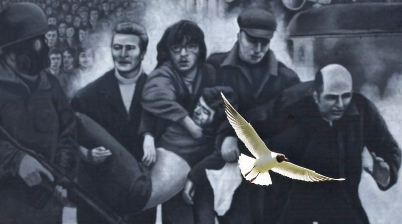 A seagull flies in front of a mural that shows a group of men, led by then-Father Edward Daly, right, carrying the body of shooting victim Jackie Duddy during 1972's Bloody Sunday in Londonderry, Northern Ireland. Archbishop Eamon Martin of Armagh has joined with leaders of other Christian traditions  in appealing for "prayerful support" for an Oct. 21, 2021, service to mark the centenary of the division of the Island of Ireland. (CNS photo/Cathal McNaughton, Reuters)