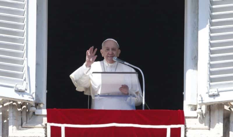 Pope Francis greets the crowd as he leads the Angelus from the window of his studio overlooking St. Peter's Square at the Vatican March 13, 2022. Appealing again for peace in Ukraine, Pope Francis said those who support violence profane the name of God. (CNS photo/Paul Haring)