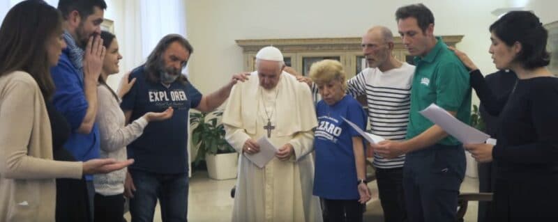 Pope Francis is pictured in an undated screenshot praying with a group of homeless people and members of the Lazare association in his residence at the Vatican. A new book, "Des Pauvres au Pape, Du Pape au Monde" ("From the Poor to the Pope. From the Pope to the World"), was to be released April 1, 2022. (CNS screenshot/YouTube)