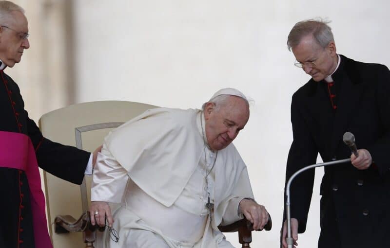 Pope Francis grimaces in pain as he gets up from his chair during the general audience in St. Peter's Square at the Vatican in this April 20, 2022, file photo. The pope told Italian newspaper Corriere della Sera that he will have knee injections for a torn ligament. (CNS photo/Paul Haring)