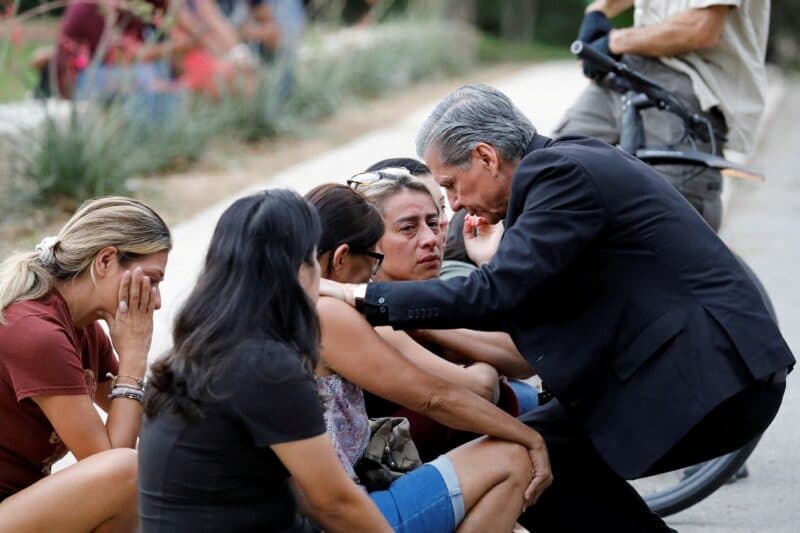Archbishop Gustavo García-Siller of San Antonio comforts people outside the SSGT Willie de Leon Civic Center, where students had been transported from Robb Elementary School after a shooting, in Uvalde, Texas, May 24, 2022. (CNS photo/Marco Bello, Reuters)