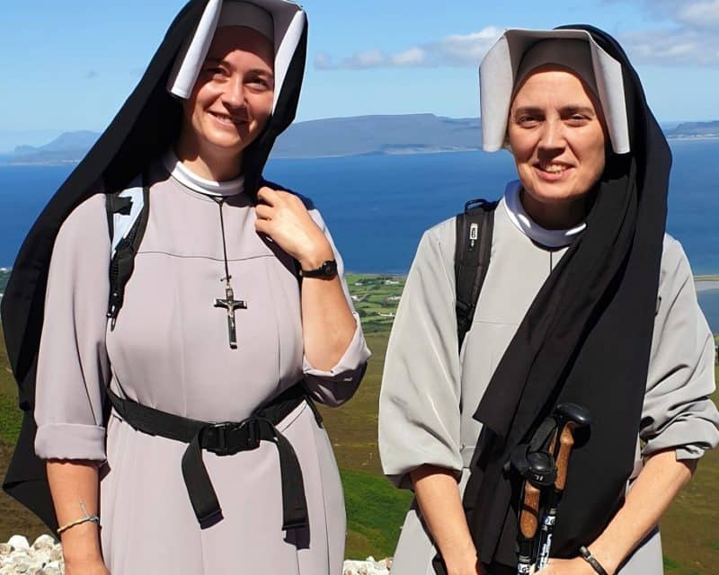 Sisters Augustina Matusik from Poland and Mary Claire Kenneally from Inagh, Ireland, members of the Congregation of Our Lady of Mercy, pose during a pilgrimage on Ireland's Croagh Patrick July 31, 2022. They joined the thousands in the first Reek Sunday climb of Croagh Patrick since the pandemic hit. (CNS photo/Sarah Mac Donald)