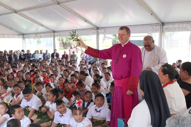 Bishop Stephen Lowe blesses students with holy water.