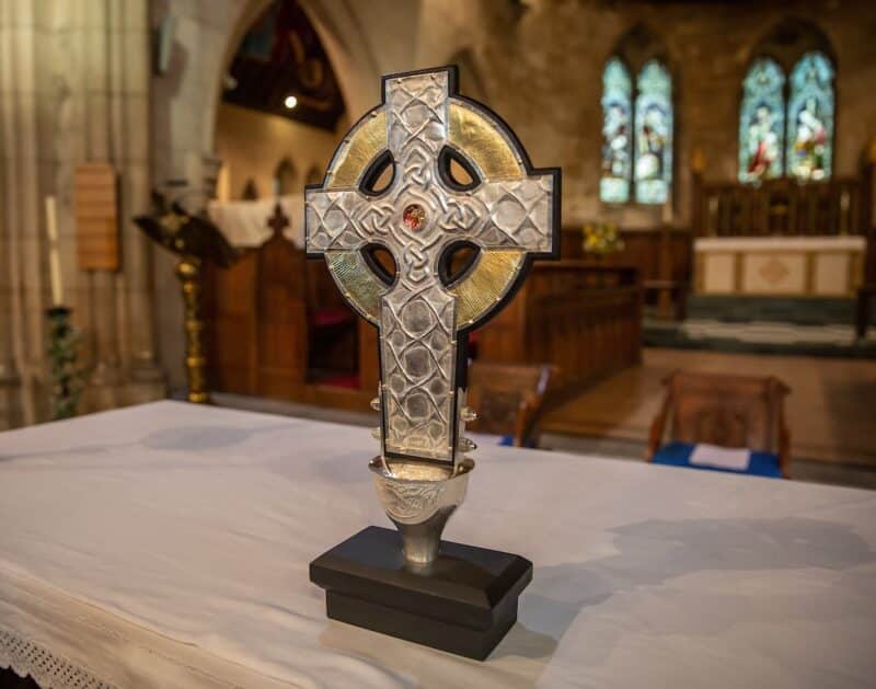 The top of the processional cross that will be used at the coronation of King Charles III in May is seen on the altar of an Anglican parish in Llandudo, Wales, April 19, 2023. Relics of the Christ's cross, a gift from Pope Francis, are under glass in the center of the processional cross. (CNS photo/Dave Custance, courtesy of the Church in Wales)
