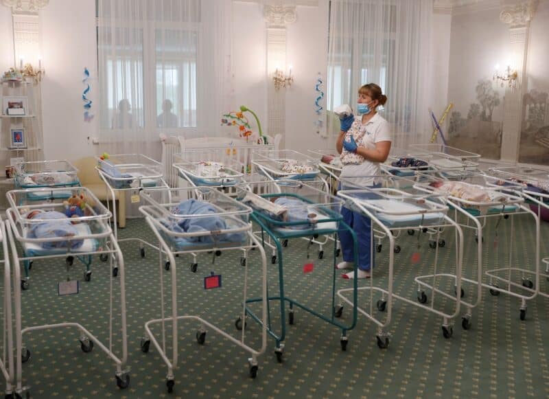 A nurse and newborns are seen in the Hotel Venice, which is owned by BioTexCom. a surrogacy agency in Kyiv, Ukraine, May 14, 2020. Dozens of babies born to surrogate mothers are stranded in Ukraine as the COVID-19 pandemic lockdown prevents their foreign parents from collecting them. The country's Catholic bishops have called for a halt to commercial surrogacy. (CNS photo/Gleb Garanich, Reuters) See UKRAINE-SURROGATES-BABIES May 15, 2020.