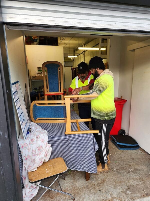 Upper Hutt Housing Trust staff Alzin Anish (who, with his mother, lives in a rental property managed by the trust) and Tama Jacobs (behind Alzin) refurbish furniture for tenants.