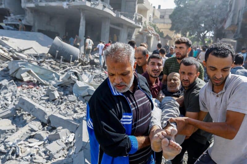 Palestinians carry a wounded man following Israeli strikes on houses in Rafah in the southern Gaza Strip Oct. 17, 2023. (OSV News photo/Ibraheem Abu Mustafa, Reuters)