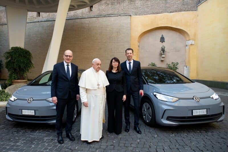 Pope Francis stands with representatives of Volkswagen at the Vatican Nov. 15, 2023, from left to right: Marcus Osegowitsch, CEO of Volkswagen Group Italia; Imelda Labbé, member of the board of management for sales and marketing at Volkswagen Passenger Cars; and Christian Dahlheim, CEO of Volkswagen Financial Services AG. They delivered the first two of dozens of electric vehicles the company will supply to Vatican City State, starting in early 2024, to support the Vatican's plans to have a net-zero-emissions fleet of vehicles by 2030. (CNS photo/courtesy of Volkswagen AG)